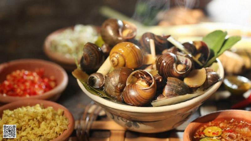 Một quán ốc ngon Sài Gòn vỉa hè nhộn nhịp về đêm, với bàn ghế nhựa thấp và nhiều khách hàng thưởng thức ốc